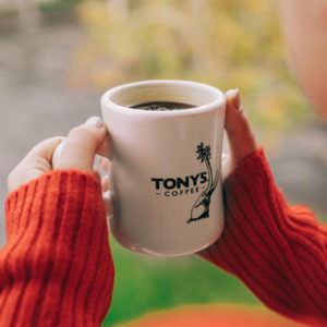 Two hands holding a Tony's Elephant diner mug.