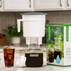 Toddy Cold Brew System sitting on a kitchen counter with a glass of cold brew