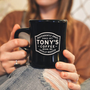 Person holding a Black Badge diner mug.