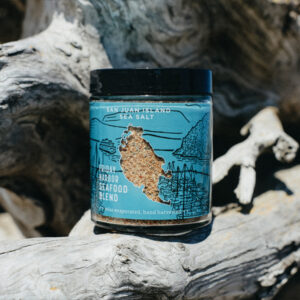 Jar of San Juan Island Sea Salt Friday Harbor Seafood Blend sitting on a piece of driftwood