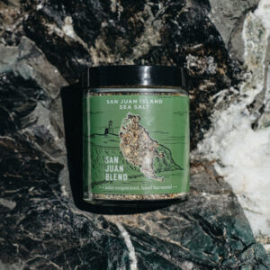 Jar of San Juan Island Sea Salt San Juan blend sitting on a grey and white rock